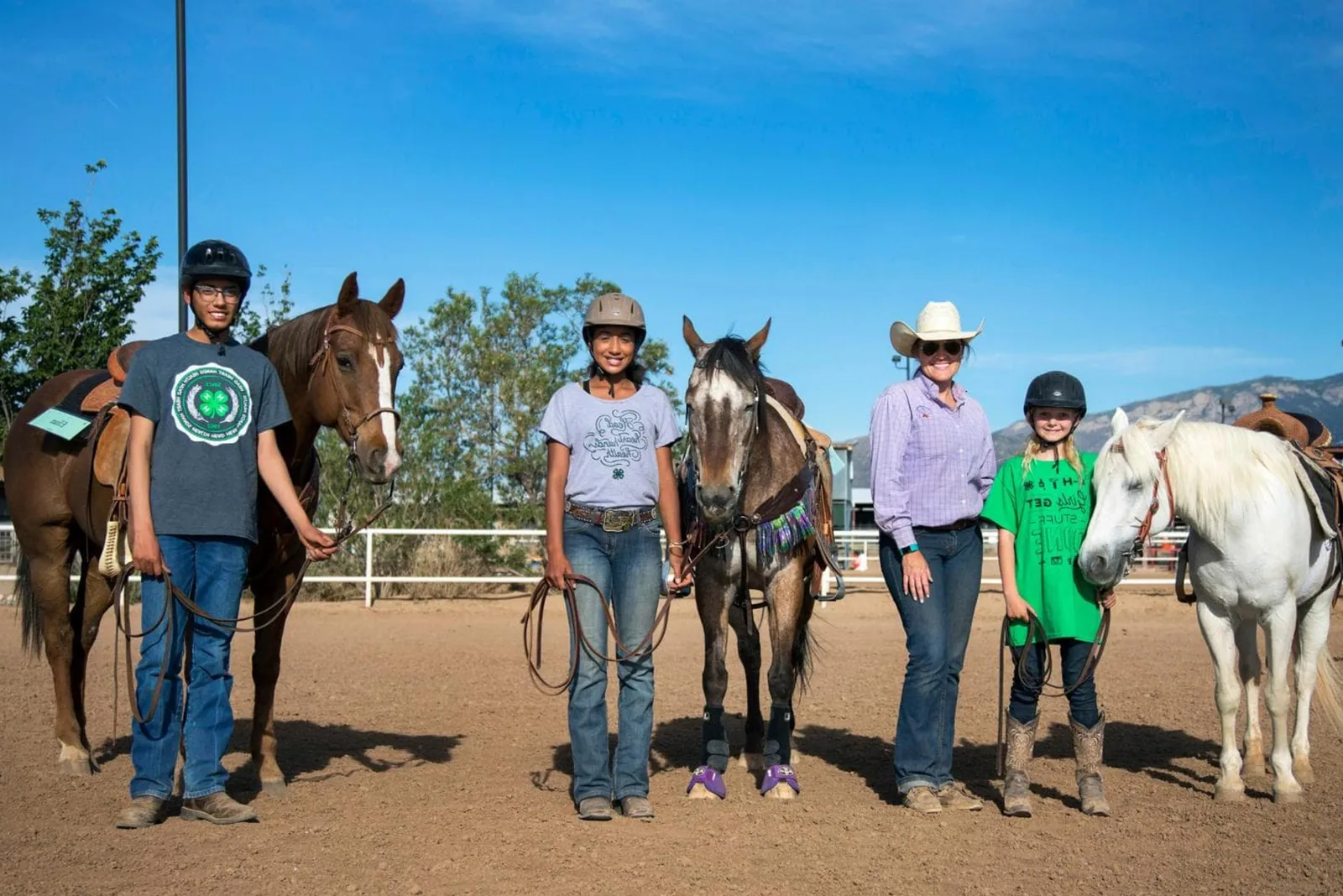 A 4-H member riding a horse in an outdoor arena