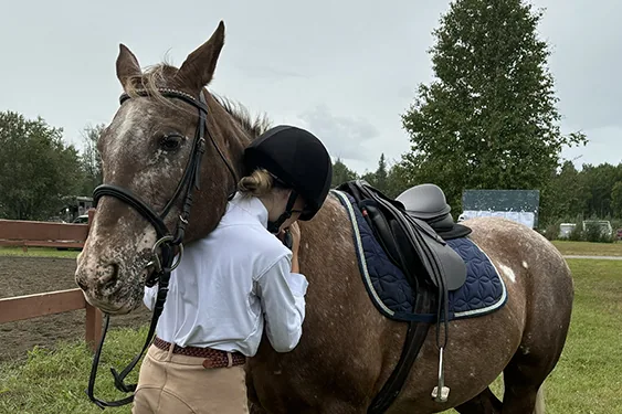 A group of 4-H members riding horses in an outdoor arena during an event.
